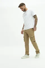 Pantalón cargo color beige, sin puños, con cuatro bolsillos con botón y pasa cintos.