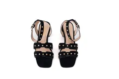 Sandalias negras de gamuza con taco cuadrado y tiras con tachas doradas.