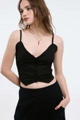 Top negro con breteles finos, escote en V y abotonadura frontal.