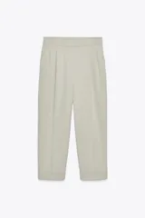 Pantalón color verde claro de tiro alto, con bolsillos delanteros, cintura elástica en la parte trasera y cierre frontal con cremallera y botones.