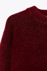 Sweater de punto color borgoña, de corte recto, cuello redondo y manga larga.