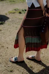 Pollera midi tejida en hilado 100% algodón, color marrón con rayas horizontales en tonos rojo y verde.