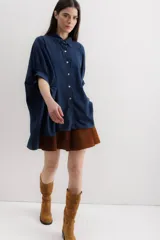 Camisa azul de mangas cortas abullonadas, con cuello clásico y cierre frontal con botones.