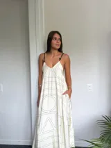 Vestido largo color beige con estampado geométrico en negro, breteles finos regulables y escote en V.