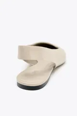 Zapato tipo bailarina destalonada color beige, con puntera fina y tira trasera elástica.