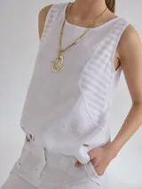 Musculosa blanca de lino con paneles laterales de tejido a rayas verticales.