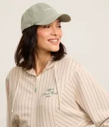 Campera deportiva color beige con rayas verticales finas, corte oversized, capucha con cordón ajustable, cierre frontal con cremallera, estampa bordada en el pecho, mangas largas ajustadas y bajo ajustado.
