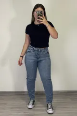 Pantalón jean mom celeste de tiro alto, corte holgado y tobillos ajustados.