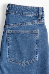 Pantalón de jean azul de tiro alto, corte wide leg y cinco bolsillos.