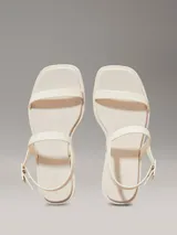 Sandalias Calvin Klein de goma color crema, con tira delantera y tira trasera ajustable con hebilla.
