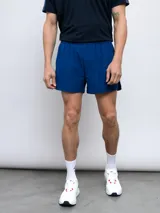 Short de entrenamiento azul con cintura elástica y logo de la marca en la pierna izquierda.