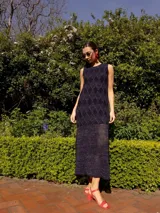 Vestido largo de punto con lurex, color azul marino, con diseño de rombos en la parte superior y tejido calado en la falda. Sin mangas y de corte recto.