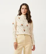 Suéter de punto color crema con cuello alto, textura de pompones y bordados florales.