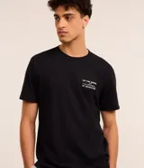 Remera negra de algodón, corte comfort, mangas cortas y cuello redondo. Estampa frontal con lettering "On the Brink of Adventure" y estampa trasera con esqueleto en canoa.