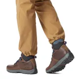 Bota de senderismo de cuero marrón con cuello acolchado negro, cordones azules y suela gris.