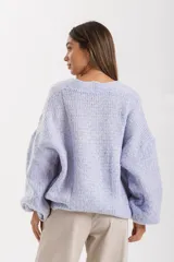 Cardigan de calce relajado y largo, confeccionado en punto grueso con cierres frontales de botones.