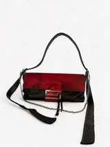 Cartera bandolera color gris con solapa de pelo blanco con estampado de círculos marrones. Cierre con botón magnético y herraje metálico plateado en forma de "S".