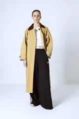 Trench color beige con cuello marrón de pana, doble botonadura y corte clásico.
