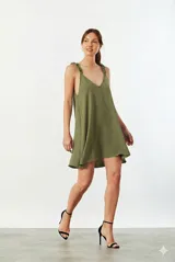 Vestido corto verde safari con escote en V, tirantes finos con volantes y corte holgado.