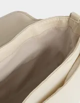 Bandolera negra de tela deportiva con correa regulable y desmontable, solapa con broche a presión y hebilla frontal con estampa.