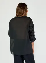 Camisa celeste de mangas 3/4 con volados en el frente y cuello en V.