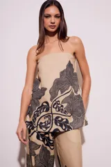 Top strapless color beige con estampado de hojas negras.