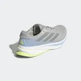 Championes de running Adidas Supernova Rise 2, color gris con detalles en azul claro y suela blanca con inserción de espuma verde lima en el talón. Presentan un exterior de malla técnica y mediasuela con tecnología Dreamstrike+.