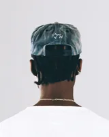 Gorra de béisbol gris con visera rígida y bordado frontal de un caballo salvaje.