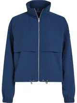 Rompevientos azul de Tommy Hilfiger, corto, con cuello alto, cierre de cremallera, dos bolsillos laterales, detalles distintivos de la marca y logo engomado bordado en la manga.