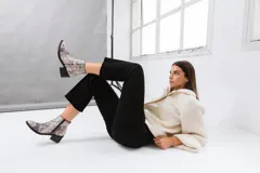 Botas cortas de cuero vacuno color marrón con estampado de piel de serpiente, taco de madera foliado en cuero y cierre lateral con cremallera.