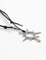 Collar con cordón negro ajustable y dije dorado con forma de sol.