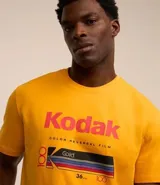 Remera amarilla de algodón con cuello redondo y mangas cortas. Estampado frontal con el logo de Kodak y un rollo de película.