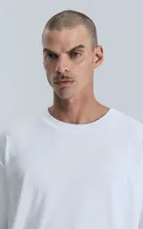 Remerón de algodón premium, color blanco liso, con corte extra oversize, hombros caídos y cuello redondo.