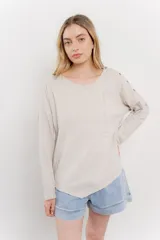 Remera celeste de manga larga con cuello redondo y bolsillo en el pecho.