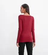 Suéter de punto color verde, con cuello barco, mangas largas y textura acanalada.