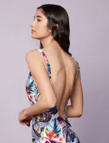 Malla enteriza estampada con motivos florales y hojas en tonos azules, rojos, amarillos y verdes. Escote en V cruzado y breteles regulables.