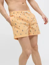 Short de baño naranja con rayas verticales blancas y estampado de tiburones azules. Cuenta con cintura elástica ajustable con cordón blanco.