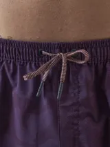 Short de baño color borgoña con estampado de hojas en tono sobre tono, cintura elástica con cordón ajustable y logo de la marca en la pierna.