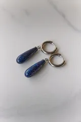 Aros colgantes de acero quirúrgico hipoalergénico con dije de piedra natural en forma de gota color azul oscuro.