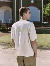 Remera color crema de manga corta y cuello redondo con estampa en la espalda con la palabra "MALIBU".