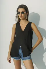 Blusa negra sin mangas con escote en V y abertura en el centro.