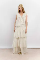 Blusa blanca de algodón con escote en V, volados en el frente y mangas cortas.