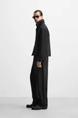Pantalón negro de corte regular, confeccionado en tejido con viscosa, con cintura elástica, bolsillos frontales y trasero de vivo.
