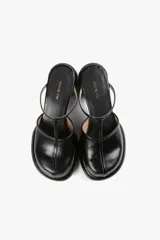 Mule color caramelo con plataforma y taco cilíndrico, tira superior negra y puntera cuadrada.