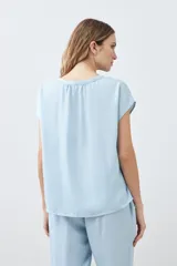 Blusa celeste de lyocell con cuello en V y mangas cortas.