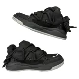 Zapatillas negras de estilo skate, con cordones gruesos y detalles en los costados.