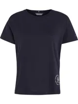Remera azul marino de cuello redondo y manga corta, confeccionada en algodón. Presenta un logo de Tommy Hilfiger en el lateral inferior.