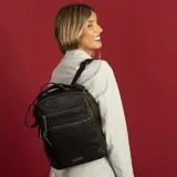 Mochila color beige de símil cuero con doble apertura superior con cierre. Incluye dos bolsillos al frente con cierres metálicos, asa rígida de mano y correa de galón. En la espalda correas de galón regulables.