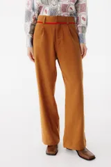 Pantalón sastrero color marrón con corte recto, tiro alto y detalle de cinta roja en la cintura.