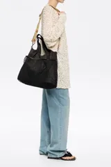 Bolso de mano grande de nailon negro con estructura blanda. Tiene doble asa de mano, asa de tejido regulable, etiqueta logotipada BIMBA Y LOLA, acabados metálicos, bolsillo interior y cierre de cordón.